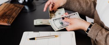 Image of woman counting cash with receipt book