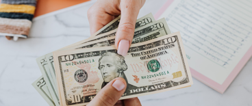photo of hands exchanging American paper money | payday lending | Tycko & Zavareei LLP