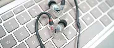 pair of earbuds resting on keyboard