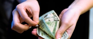 person holding and counting paper money