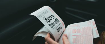 person holding multiple lottery tickets in hands