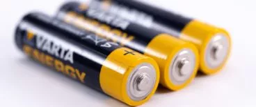 three batteries sitting next to each other on a flat, white surface
